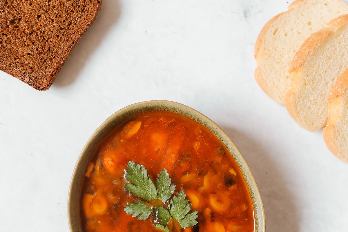 Мясная солянка с оливками и лимоном в тарелке